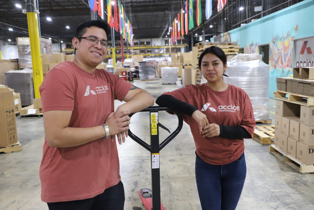 Acción Performance team standing by pallet jack.